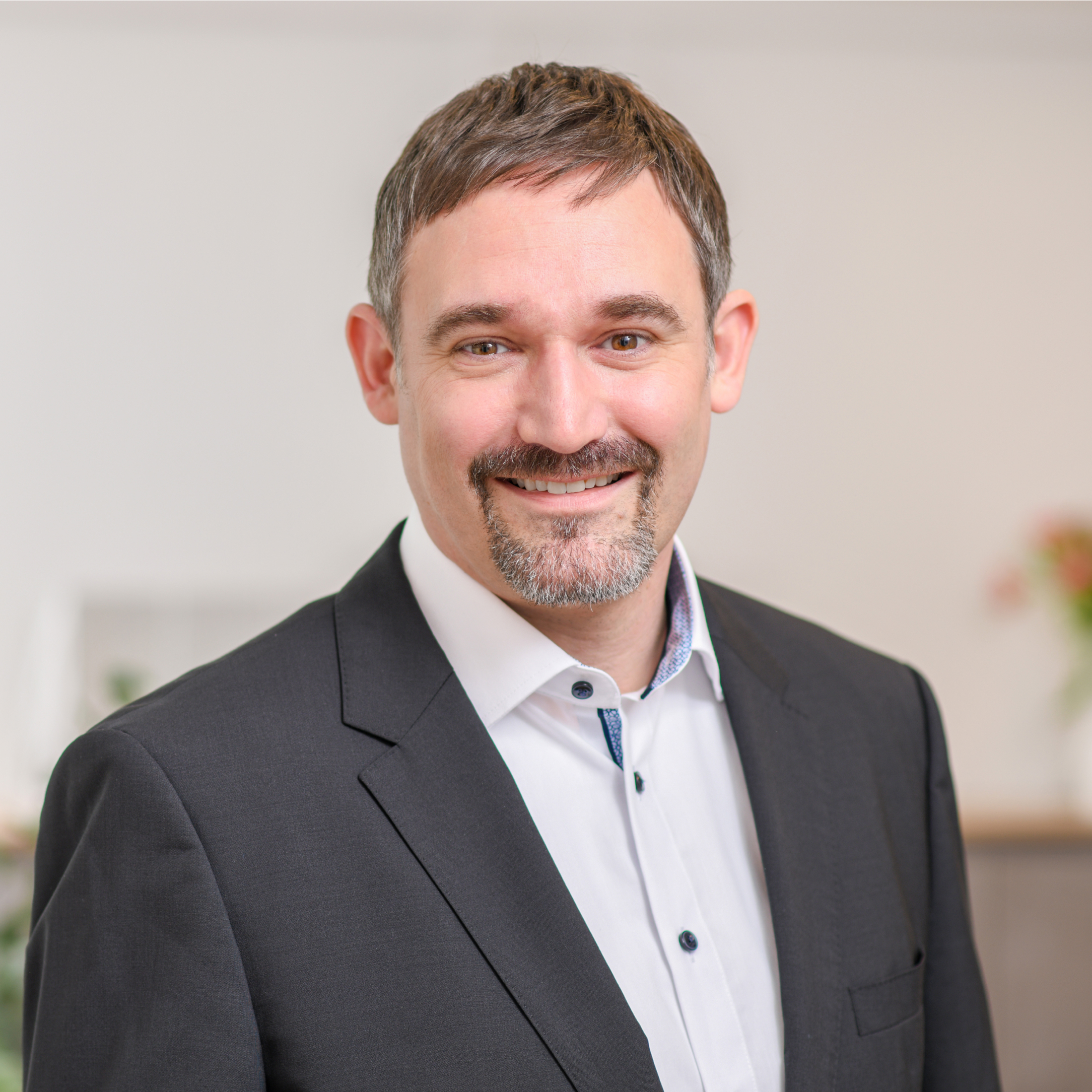 Freundlich lächelnder Mitarbeiter der LZS Steuerberatung im Business-Outfit